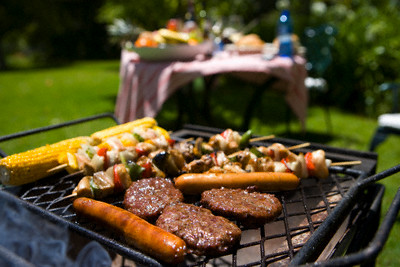 Food on barbecue by table in garden